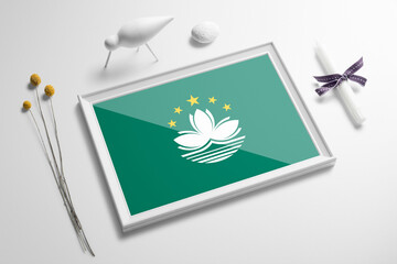 Macao flag in wooden frame on table. White natural soft concept, national celebration theme.