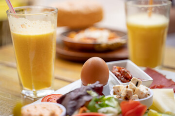 Close-up of egg with meal served by juice on table at sidewalk cafe