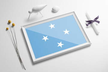 Micronesia flag in wooden frame on table. White natural soft concept, national celebration theme.