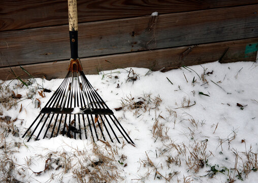 Conceptual image of Old rake and snow