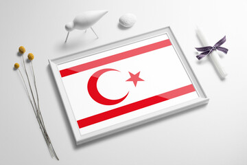 Northern Cyprus flag in wooden frame on table. White natural soft concept, national celebration theme.