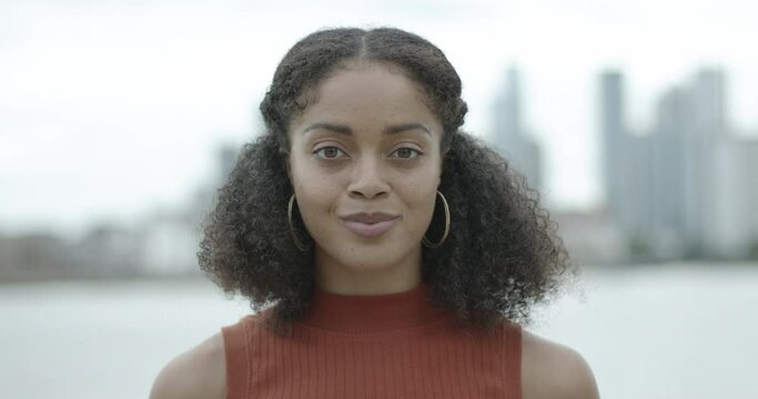 Portrait of independent young adult Afro American woman looking at camera happy wearing red top