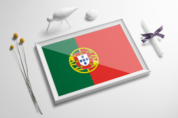 Portugal flag in wooden frame on table. White natural soft concept, national celebration theme.