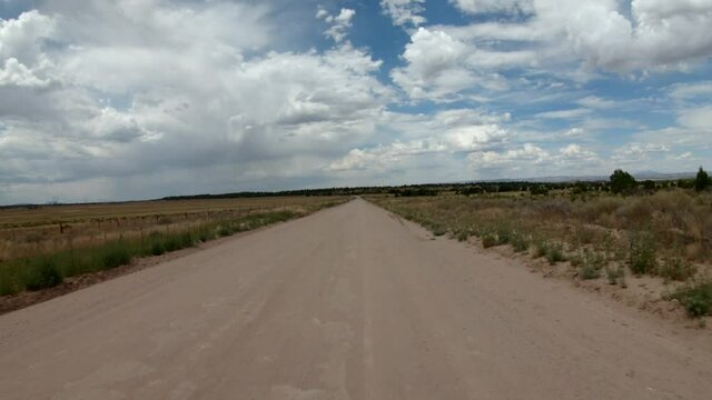 4k POV Driving Plate On A Dirt Road With Dramatic Clouds Overhead