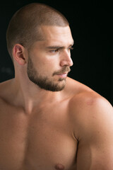 Fototapeta premium portrait of a man. A man with a naked athletic torso poses in a photo studio on a white background. A healthy image of a strong, well-trained male body. Shows the muscles.
