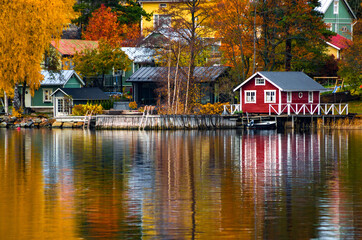 Colorful houses and trees reflecting in the water surface. Autumn in Rauma, Finland.
