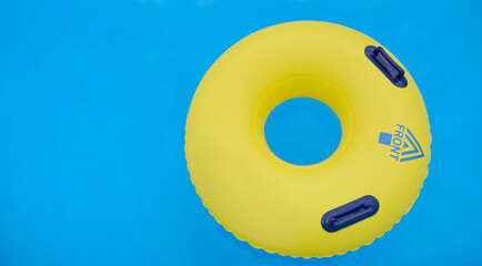 yellow colorful swimming circle with handles with the inscription forward directed to the right 