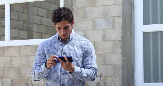 Young elegant man. gaming a video game on his cellphone 