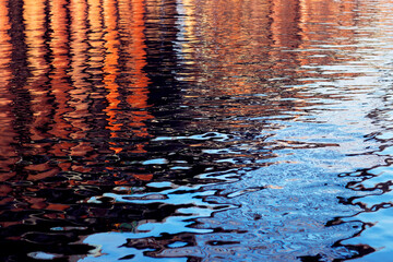 Fototapeta na wymiar The small water ripples texture in navy blue and orange colors. The abstract photo was shot for your colorful design.