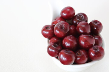 Fresh juicy cherries in a bowl maco close up isolated on white background