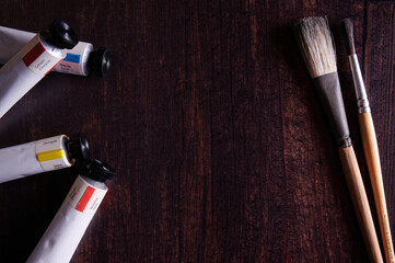 Artist paint brushes and paint on wooden table
