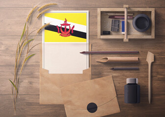 Brunei invitation, celebration letter concept. Flag with craft paper and envelope. Retro theme with divide, ink, wooden pen objects.