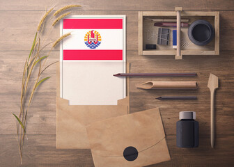 French Polynesia invitation, celebration letter concept. Flag with craft paper and envelope. Retro theme with divide, ink, wooden pen objects.