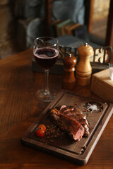 Tasty roasted meat served on wooden table in restaurant. Cooking food