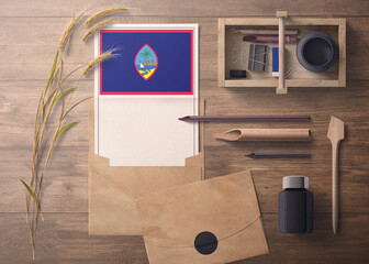 Guam invitation, celebration letter concept. Flag with craft paper and envelope. Retro theme with divide, ink, wooden pen objects.