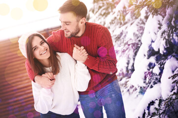 Lovely couple spending time together on snowy day. Winter vacation