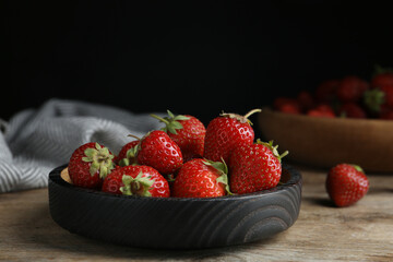 Delicious ripe strawberries on wooden plate, closeup