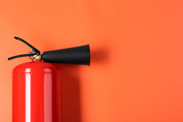 Fire extinguisher on orange background, top view. Space for text