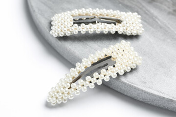 Stylish hair clips and board on white background