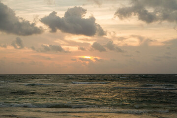 Paradise. The sea and ocean waves at sunrise. Daybreak orange and purple colors.