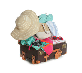 Open vintage suitcase with different beach objects packed for summer vacation isolated on white