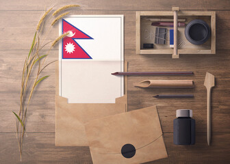 Nepal invitation, celebration letter concept. Flag with craft paper and envelope. Retro theme with divide, ink, wooden pen objects.