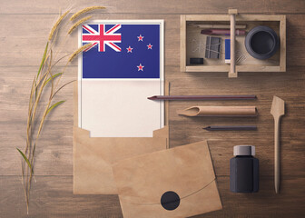 New Zealand invitation, celebration letter concept. Flag with craft paper and envelope. Retro theme with divide, ink, wooden pen objects.