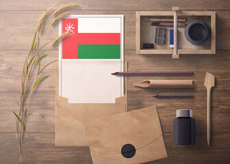 Oman invitation, celebration letter concept. Flag with craft paper and envelope. Retro theme with divide, ink, wooden pen objects.