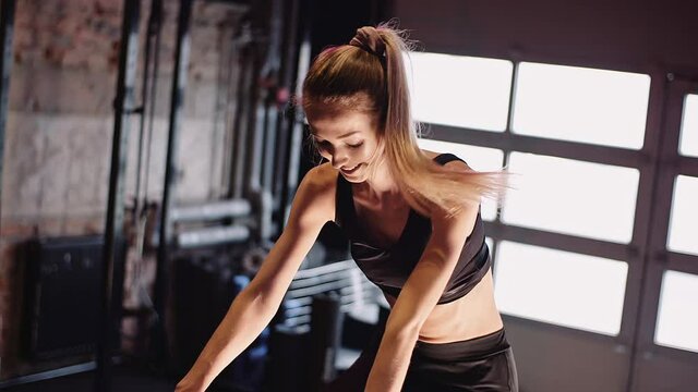Young Fit Sporty Blone Girl Exercising on a Bike at Gym