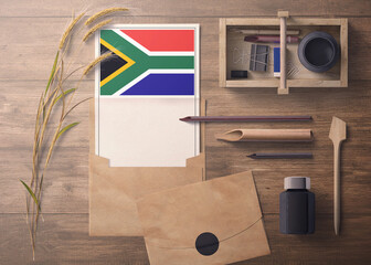 South Africa invitation, celebration letter concept. Flag with craft paper and envelope. Retro theme with divide, ink, wooden pen objects.