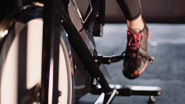 Young Fit Sporty Blone Girl Exercising on a Bike at Gym