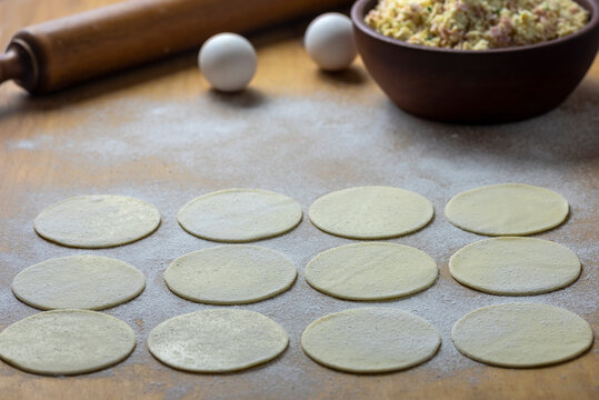 
tapas of empanadas or crepes on a table with a stick to knead eggs and flour, ingredients for a preparation.