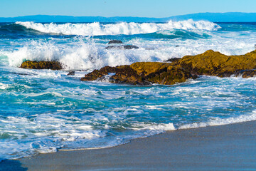 Waves crashing in to rocks on the shores of Pacific Ocean in California