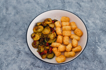 plant-based food, sauteed mediterranean vegetables with soy sauce and wir fried potato royals