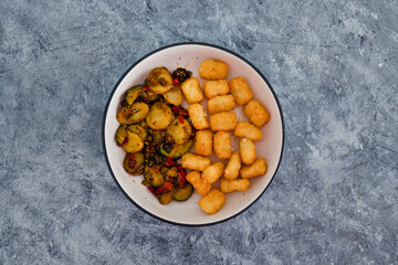 plant-based food, sauteed mediterranean vegetables with soy sauce and wir fried potato royals