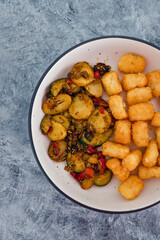 plant-based food, sauteed mediterranean vegetables with soy sauce and wir fried potato royals