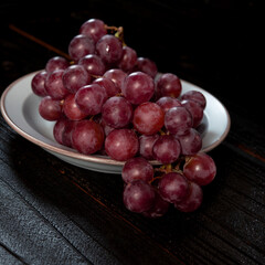 Bunch of red grape isolated on dark wood background