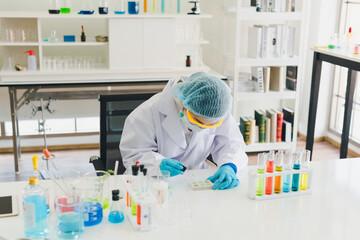 Asian scientists are preparing chemicals for testing and analysis in the laboratory. Scientists clear glasses and white shirts. Science and Chemistry Concept