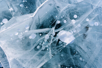 Beautiful ice of Lake Baikal with abstract cracks and frozen air bubbles