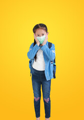 Asian child girl wearing medical mask isolated on yellow background