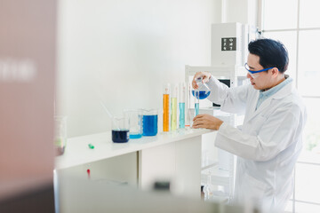Fototapeta na wymiar Asian scientists are preparing chemicals for testing and analysis in the laboratory. Scientists clear glasses and white shirts. Science and Chemistry Concept