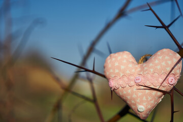 An image of a soft toy in the shape of a heart. Handicraft work.