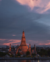 Fototapeta premium Templo Wat Arun al atardecer con el cielo lleno de nubes