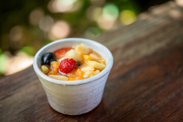 Small portion fruit salad on table with blurred background.