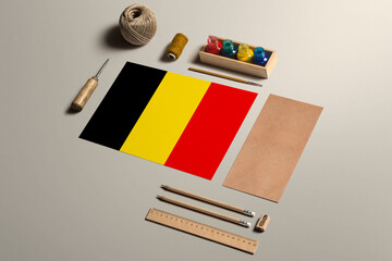 Fototapeta na wymiar Belgium calligraphy concept, accessories and tools for beautiful handwriting, pencils, pens, ink, brush, craft paper and cardboard crafting on wooden table.