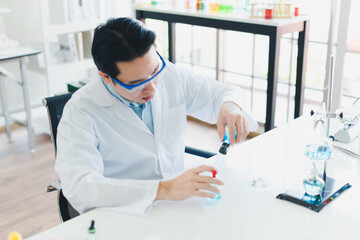 Asian scientists are preparing chemicals for testing and analysis in the laboratory. Scientists clear glasses and white shirts. Science and Chemistry Concept