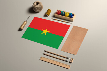 Burkina Faso calligraphy concept, accessories and tools for beautiful handwriting, pencils, pens, ink, brush, craft paper and cardboard crafting on wooden table.
