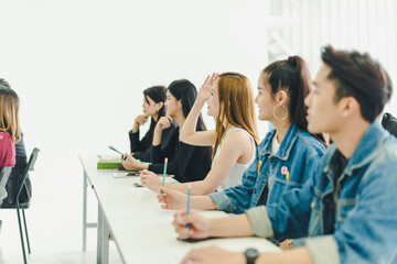 Asians attend seminars and listen to lectures from speakers in the training room.  Some people raised their hands to ask the narrator. 