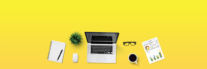 Top view business office desk with laptop, coffee, notebook, a report paper, and office supplies / Creative flat lay photo of workspace desk and copy space / Panoramic banner yellow background