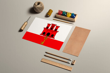 Gibraltar calligraphy concept, accessories and tools for beautiful handwriting, pencils, pens, ink, brush, craft paper and cardboard crafting on wooden table.